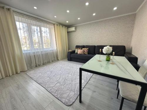a living room with a table and a couch at Sky Apartment Bolashak in Aktobe