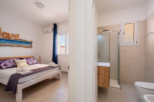 - une chambre avec un lit et une douche dans l'établissement Lèvè – Sea Nature Stay, à Torre Lapillo