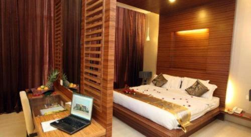 a bedroom with a bed and a laptop on a desk at Uptown Imperial Kajang in Kampong Sungai Kantan