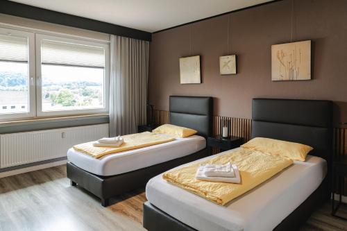 a hotel room with two beds and a window at SchönHier in Westerburg