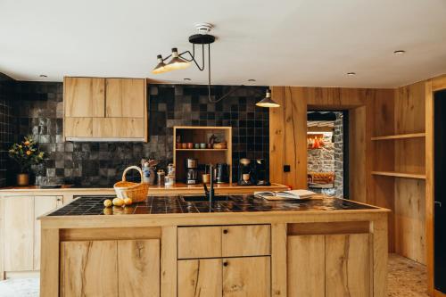 a kitchen with wooden cabinets and a counter top at La Source du Lodji by WelcHome in Spa