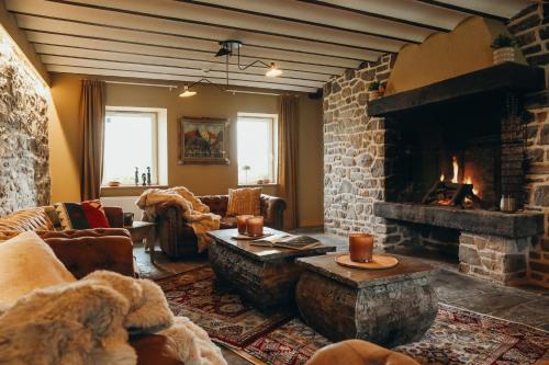a living room with a large stone fireplace at La Source du Lodji by WelcHome in Spa