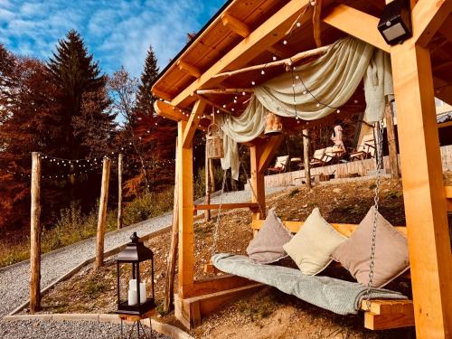 a porch with a swing with pillows on it at Cabana KayLuna in Mătişeşti