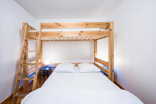 Un dormitorio con dos literas y una escalera. en Appartement Aigueblanche, en La Lechere