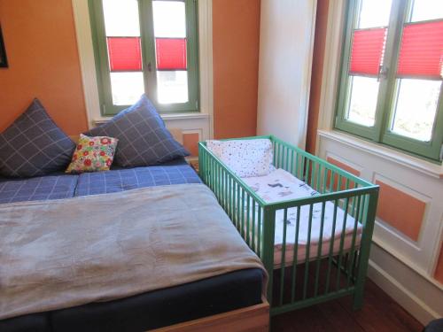 拜尔斯布龙Ferienwohnung-Schoenmuenzblick-Urlaub-im-Nationalpark-Schwarzwald-Schwarzwald-Plus-inklusive的有两张床、一张婴儿床和窗户的房间