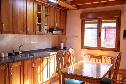 a kitchen with a table and a sink and a table and chairs at El Rincon de Onís in Bobia de Abajo