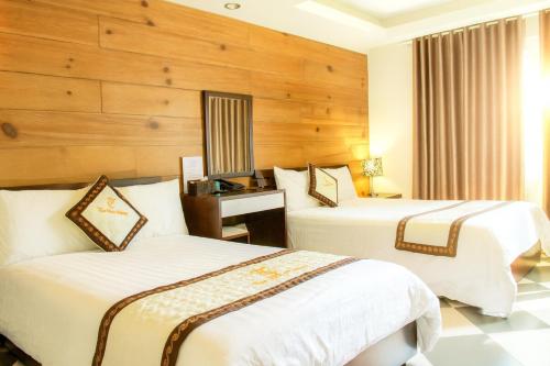 a hotel room with two beds and a desk at Thai Hoa Hotel in Hanoi