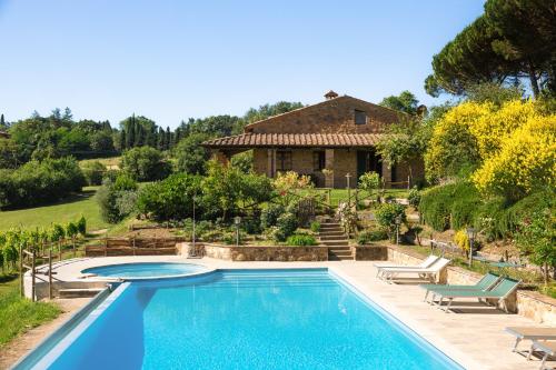 a swimming pool in front of a house at Agriturismo Il Serraglio in Montepulciano