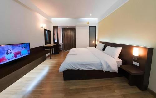 une chambre avec un lit et une télévision à écran plat dans l'établissement Next Bird Suite, à Bangkok