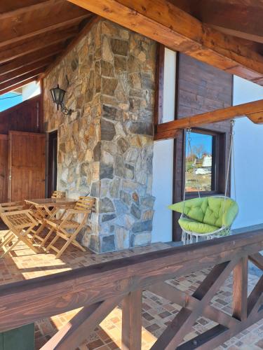 a porch of a log cabin with a stone wall at Planinska kuća Radulović in Goč