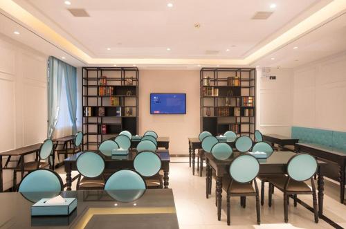 a classroom with tables and chairs in a room at Xana Lite·Nanchang Changbei Jiangxi University of Finance and Economics in Nanchang