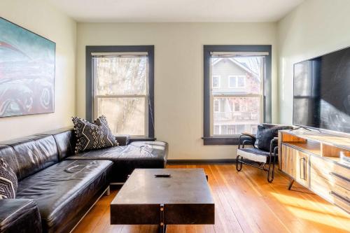 a living room with a leather couch and a coffee table at Stay Portland - Portland Classic - Walk to Local Coffee & Food in Portland