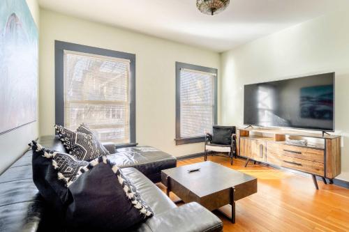 a living room with a couch and a flat screen tv at Stay Portland - Portland Classic - Walk to Local Coffee & Food in Portland
