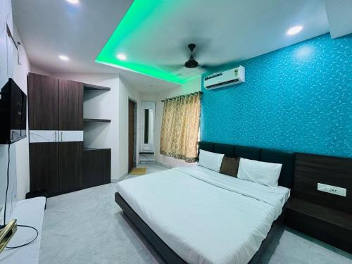 ein Schlafzimmer mit einem Bett mit einer blauen Wand in der Unterkunft Hotel G7 in Indore