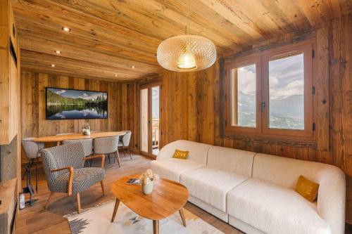una sala de estar con un sofá y una mesa en Chalet Reine - Belle vue Mont-Blanc, en Combloux