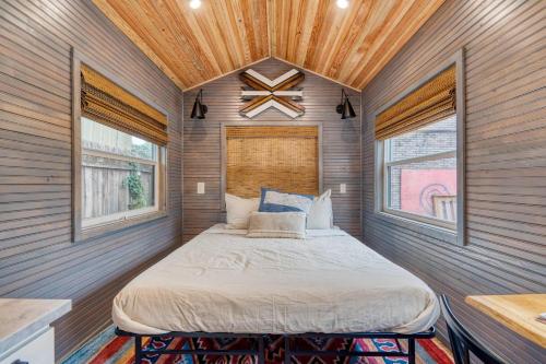 a bed in a small room with two windows at Stay Portland - Tiny Aztec - Walk to Local Shops & Restaurants in Portland