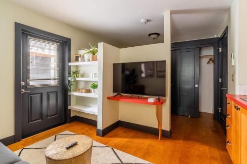 a living room with a red table and a door at Stay Portland - Quirky Micro Apt - Foodies, Artists, Coffee Lovers in Portland