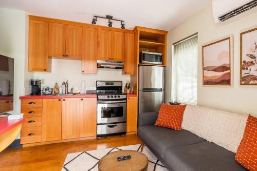 a living room with a couch and a kitchen at Stay Portland - Quirky Micro Apt - Foodies, Artists, Coffee Lovers in Portland