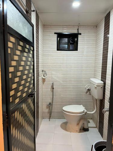 a bathroom with a toilet and a window at WKND Casa in Panchgani