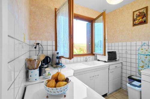 a kitchen with a bowl of fruit on a counter at La petite maison a la campagne in Nantheuil