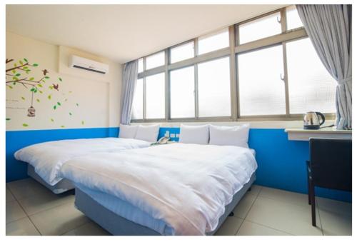 a bedroom with two beds and a window at Ryhan Hotel in Zhongli