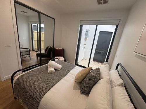 a bedroom with a large bed with a large mirror at Urban Pause Retreat - Wollert in Wollert