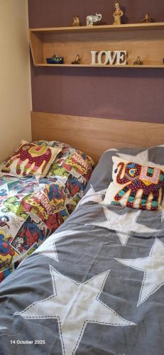 una cama con dos almohadas encima en Heavenly Huts GC056, en Saint Osyth