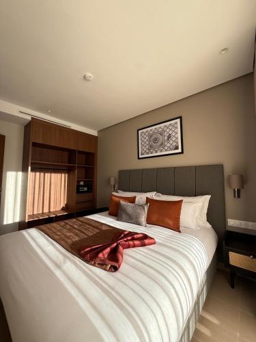 ein Schlafzimmer mit einem großen Bett mit einem roten Bademantel darauf in der Unterkunft Dally Apart Hotel in Rabat