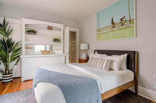 a bedroom with a white bed with a bike on the wall at Stay Portland - Portland Classic - Parks, Eateries & Local Shops in Portland