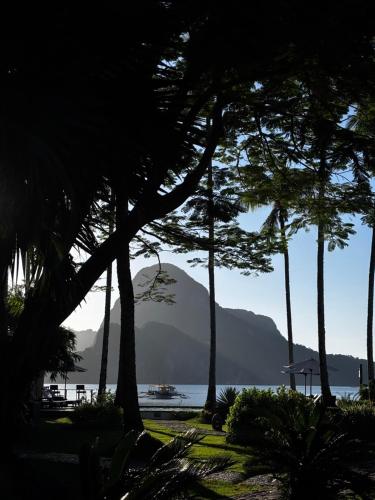 a group of trees with a mountain in the background at Cadlao Resort and Restaurant in El Nido