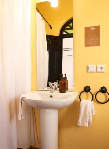 a bathroom with a white sink and a mirror at Dar Rass El Maa in Chefchaouen