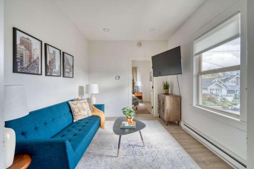 a living room with a blue couch and a table at Stay Portland - Mt Tabor Retreat - Local Eateries - Shops - Bars in Portland