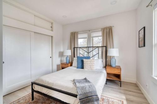a bedroom with a bed and two lamps and a window at Stay Portland - Mt Tabor Retreat - Local Eateries - Shops - Bars in Portland