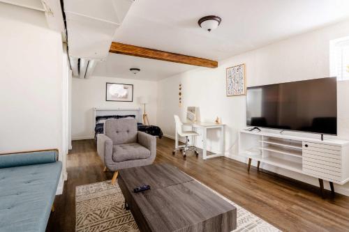 a living room with a large television and a couch at Cozy Portland Home Steps from Food - Sleeps 4 in Marquam Hill