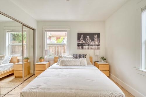 a bedroom with two beds and two windows at Stay Portland - The Sunnyside Cottage, Local Shops & Nightlife in Portland