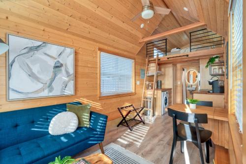 a living room with a blue couch and wooden walls at Stay Portland - Tiny Refuge - Quiet & Cozy in Woodstock