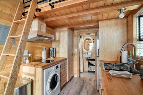 a kitchen with a washer and dryer in a tiny house at Stay Portland - Tiny Refuge - Quiet & Cozy in Woodstock