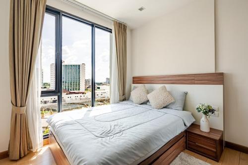 a bedroom with a large bed and a large window at Astra condo - Deluxe room in Chiang Mai