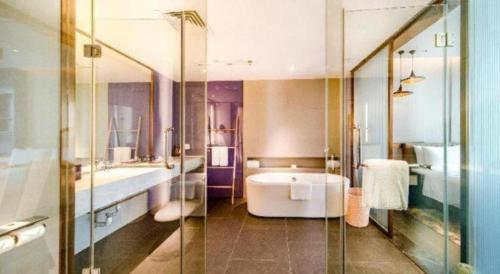 a bathroom with a tub and a sink and a shower at Four Points by Sheraton Haikou International Airport in Haikou