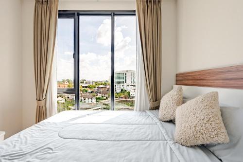 a bedroom with a large bed with a large window at Astra condo - Deluxe room in Chiang Mai