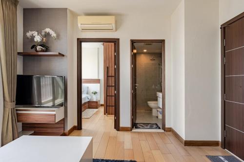 a bathroom with a television and a bathroom with a toilet at Astra condo - Deluxe room in Chiang Mai