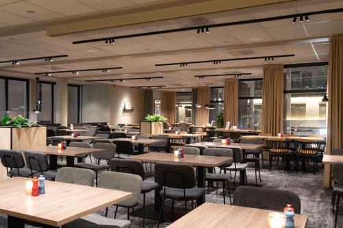 Scandic Victoria Lillehammer في ليلهامر: مطعم به طاولات وكراسي ونوافذ