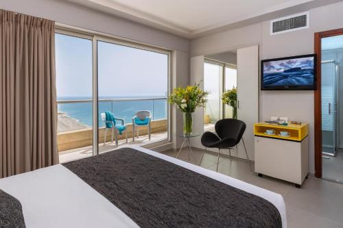a hotel room with a large bed and a large window at מלון ארנה בת ים - לאונרדו לשעבר in Bat Yam