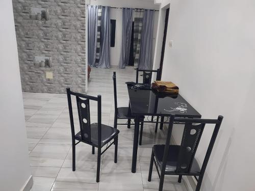 une salle à manger avec une table et des chaises noires dans l'établissement FassoImmoPrestige, 