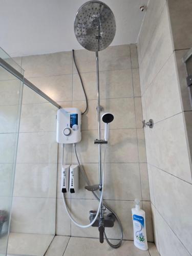 una ducha con cabezal de ducha en un baño en The Octagon -The City Centre Signature Suite in Ipoh, en Ipoh
