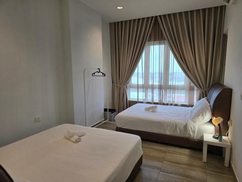 Una habitación de hotel con dos camas y una ventana. en The Octagon -The City Centre Signature Suite in Ipoh, en Ipoh