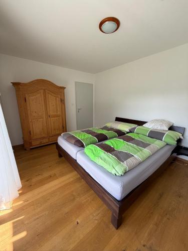 a bedroom with a large bed in a room with wooden floors at Savognin Rundigna in Savognin