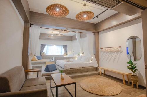 a bedroom with a bed and a living room with a couch at Krung Boutique Hotel in Bangkok
