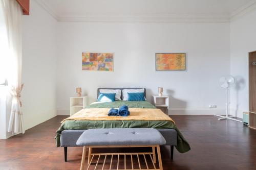 a bedroom with a large bed with blue pillows at Quinta das Virtudes in Funchal