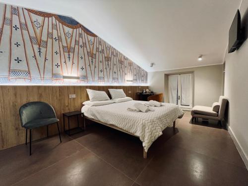 a bedroom with a bed and a large painting on the wall at Antica Dimora Palazzo Ciprani in Anagni